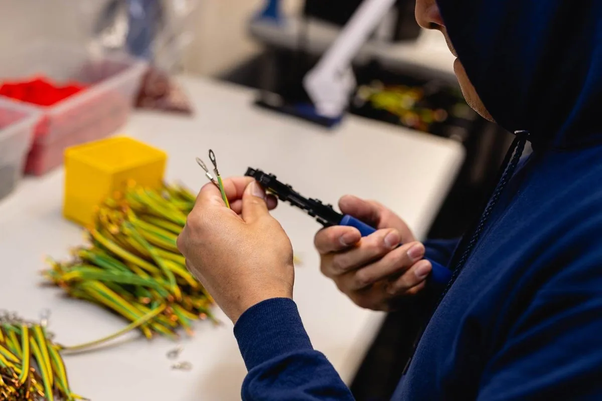 Technician performing detailed cable assembly work